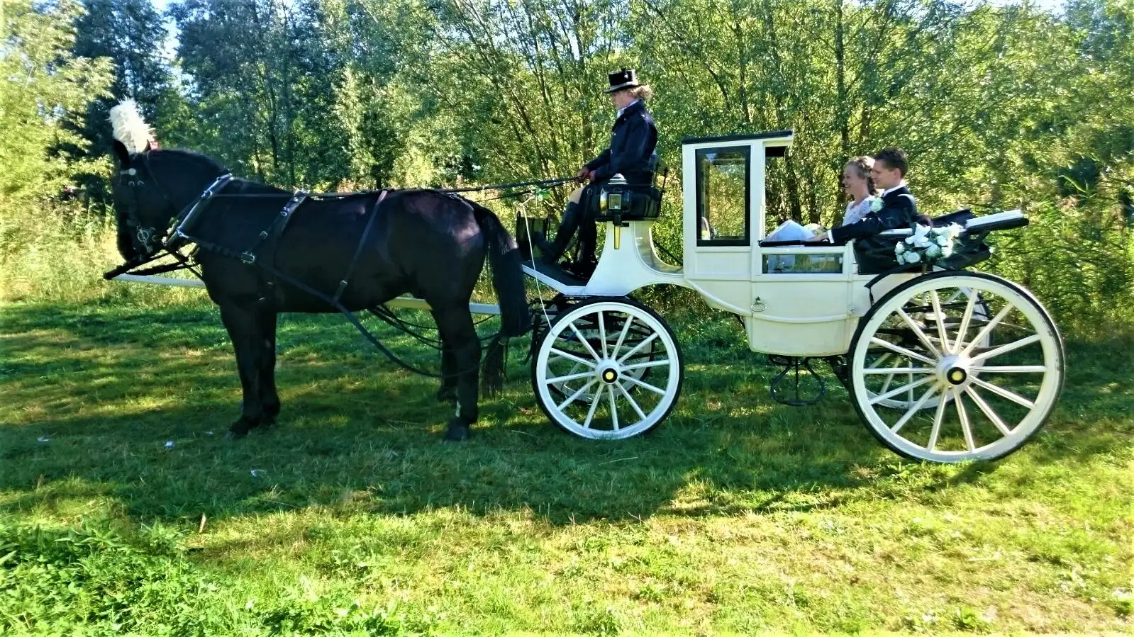 Witte landaulet met bruidspaar in een zonnig park